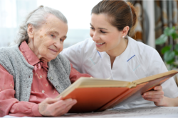 caregiver and senior woman reading a book